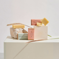 Charger l'image dans la visionneuse de la galerie, Patomia dog shampoo bars in eco-friendly packaging with natural soap blocks displayed on stone and wooden pedestals.