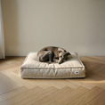 Charger l'image dans la visionneuse de la galerie, Patomia square dog bed in beige linen blend fabric with recycled foam filling, featuring a grey dog resting on top.