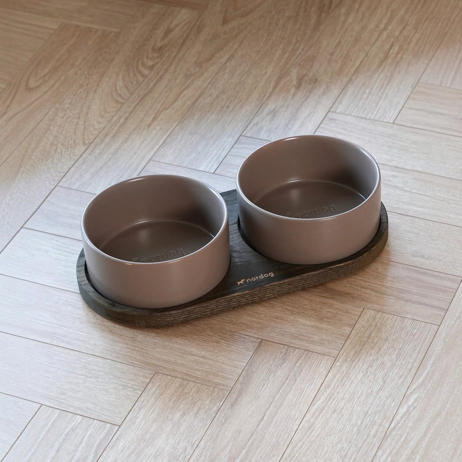 Patomia Barcelona double dog bowl set with a dark smoked oak base and two mocha ceramic bowls on a wooden floor.
