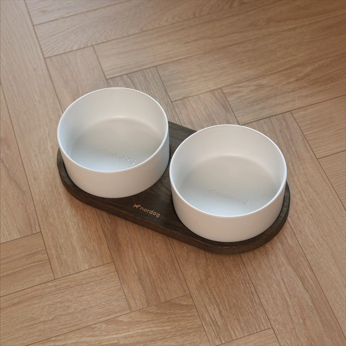 Patomia Barcelona double dog bowl with a dark smoked oak base and two white ceramic bowls on a wooden floor
