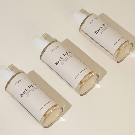 Patomia Bark Bliss natural dog conditioning spray bottles for hydrating and detangling pet fur on a beige background.