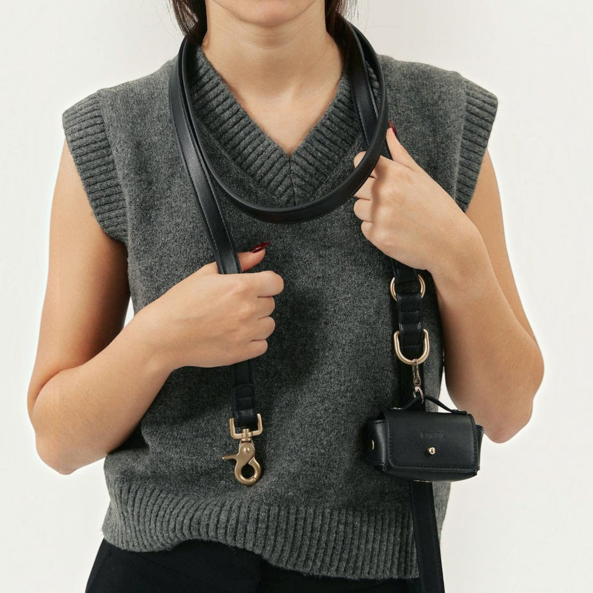 Patomia black vegan leather dog leash with zamak metal hardware and matching accessory pouch worn over the shoulder