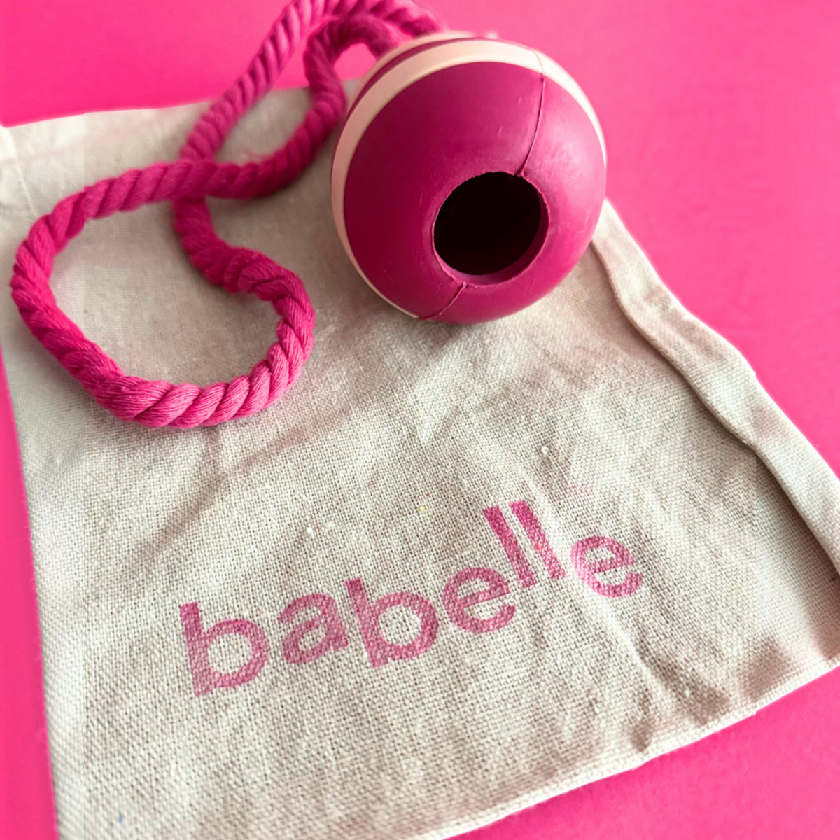 Patomia Bubble Feeder dog treat toy in pink and white silicone with a matching pink rope on a branded canvas bag