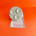 Charger l'image dans la visionneuse de la galerie, Patomia The Dreamy green silicone lickmat with a round design for pet enrichment on a linen bag against orange background
