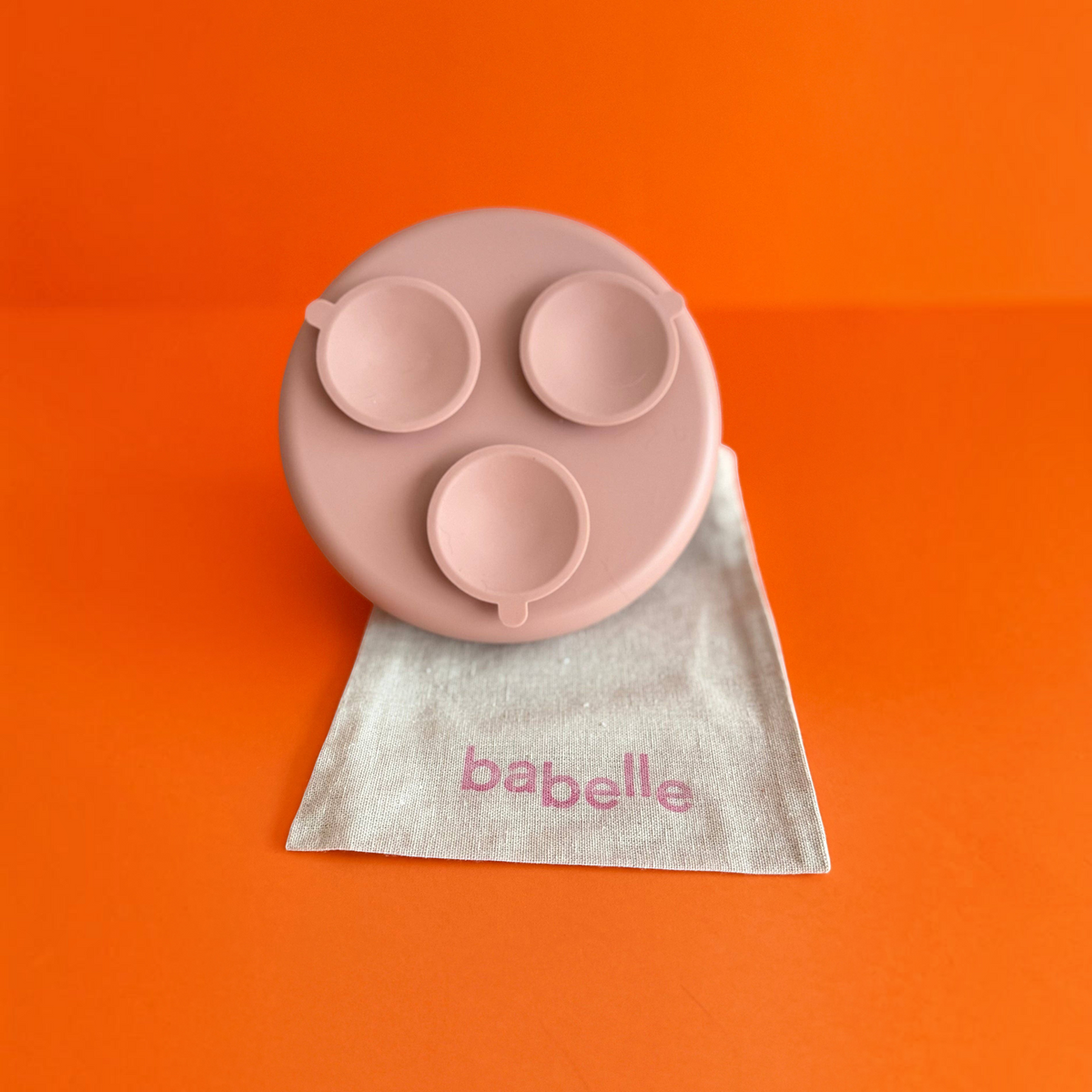 Patomia The Dreamy round silicone lickmat in vieux rose with three suction cups on a beige fabric bag