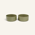 Charger l'image dans la visionneuse de la galerie, Two olive green Patomia ceramic dog bowls with a minimalist design and smooth finish on a light background
