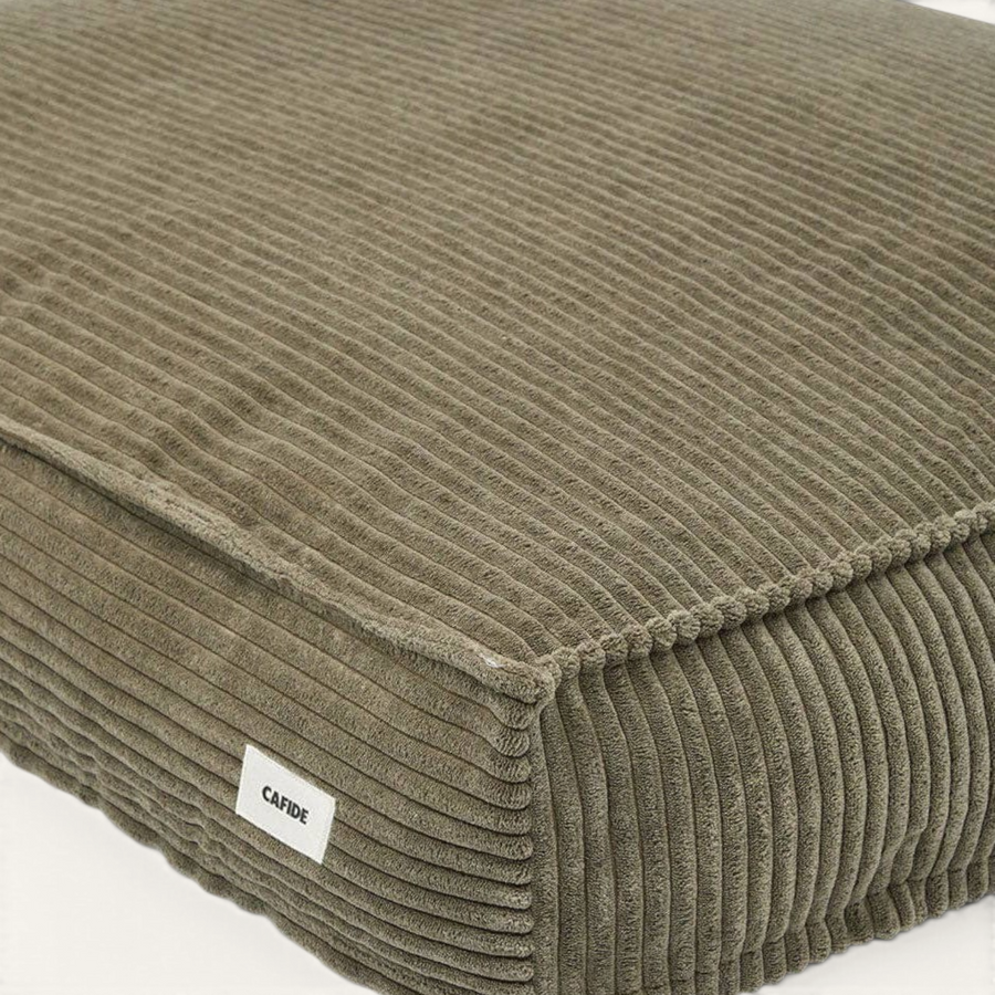 Patomia green corduroy dog bed with a soft, textured fabric surface and a small branded label on the side.
