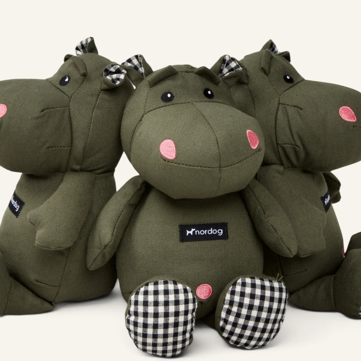 Patomia Henny olive green plush hippopotamus dog toy with black and white checkered accents on ears and feet.