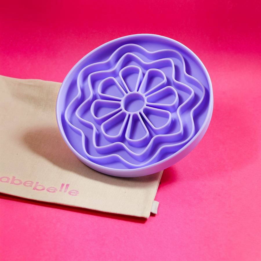 Patomia The Petal lilac silicone lickmat for dogs with a daisy-inspired design on a bright pink background.