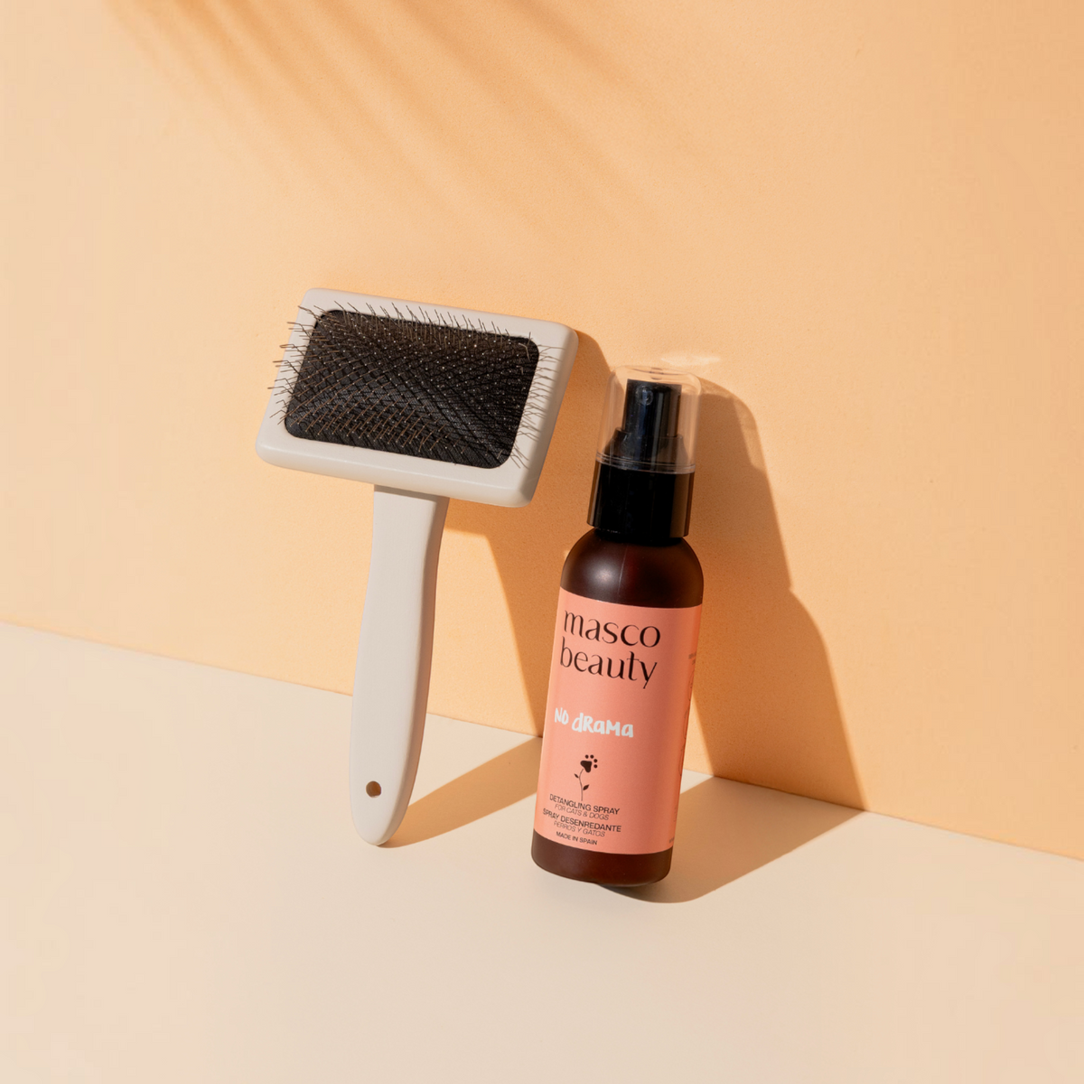 Patomia Masco Beauty professional dog grooming brush and detangling spray bottle on a beige background