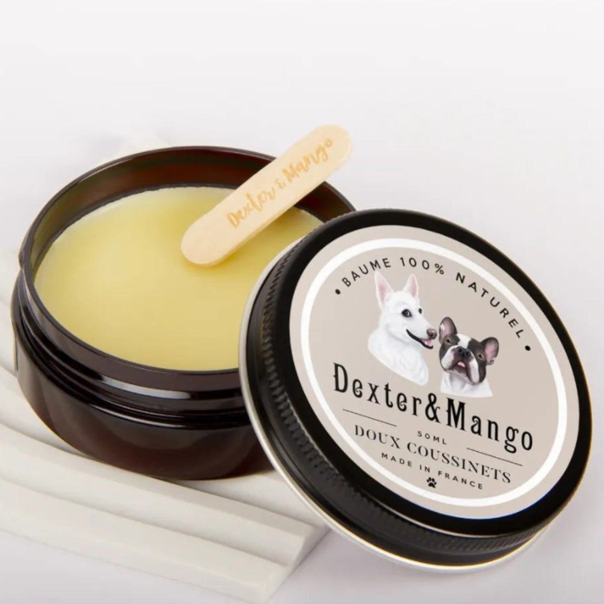 Patomia natural paw balm for dogs in a 50ml jar with a wooden applicator, featuring a cream-colored soothing salve.