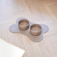 Charger l'image dans la visionneuse de la galerie, Patomia Nordog ceramic dog bowls in cacao brown on a bone-shaped non-slip mat on a light wood floor
