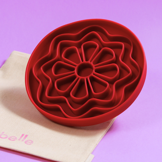 Patomia The Petal dog lickmat in bordeaux red silicone with a flower-shaped design on a light purple background