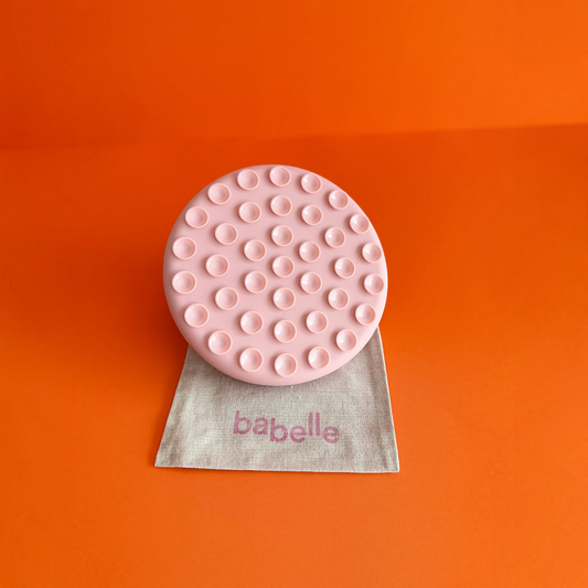 Patomia The Petal lickmat in vieux rose silicone with suction cups on a beige fabric bag against an orange background
