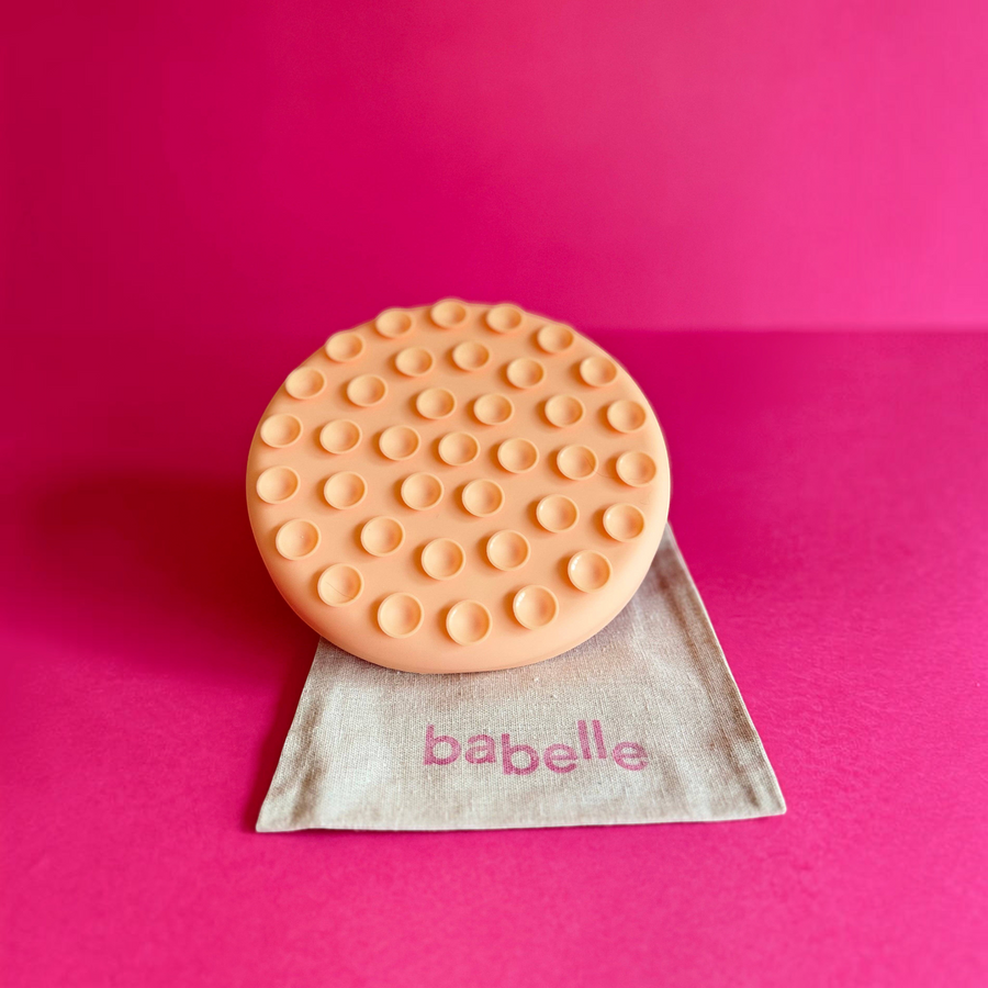Patomia The Petal peach silicone lickmat for dogs on a linen bag against a vibrant pink background