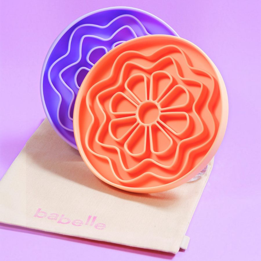 Patomia The Petal peach and lilac silicone flower-shaped lick mats for dog enrichment on a beige fabric bag