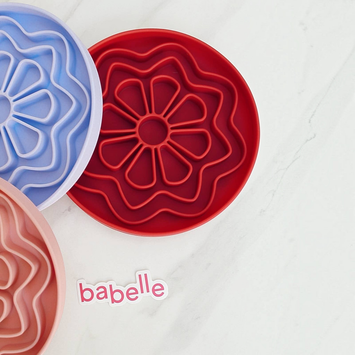 Patomia The Petal silicone dog lickmats in bordeaux red, lilac, and peach, featuring a flower-shaped design.