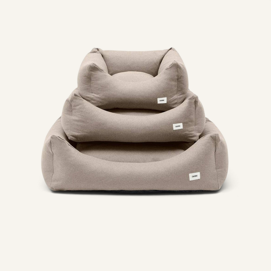 Patomia Snozy beige dog bed basket with soft removable cover and recycled foam filling, shown in three sizes stacked.