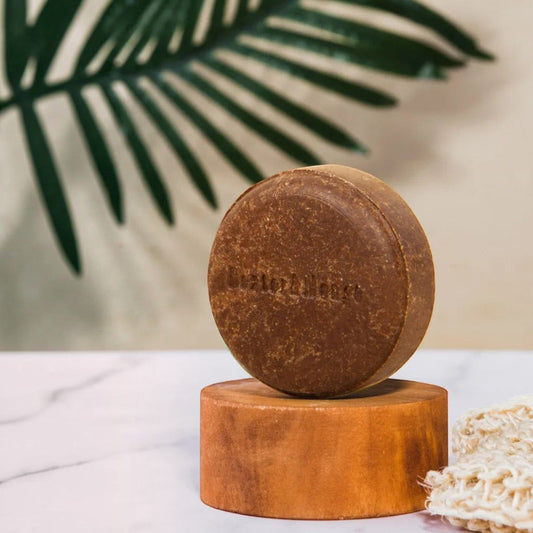 Patomia P'tit mousse natural solid dog shampoo bar on a wooden stand with a sisal sponge in a bright setting